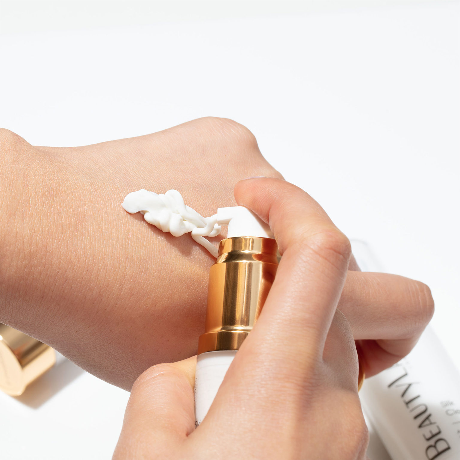 Hand dispensing BeautyLab product onto the back of opposite hand