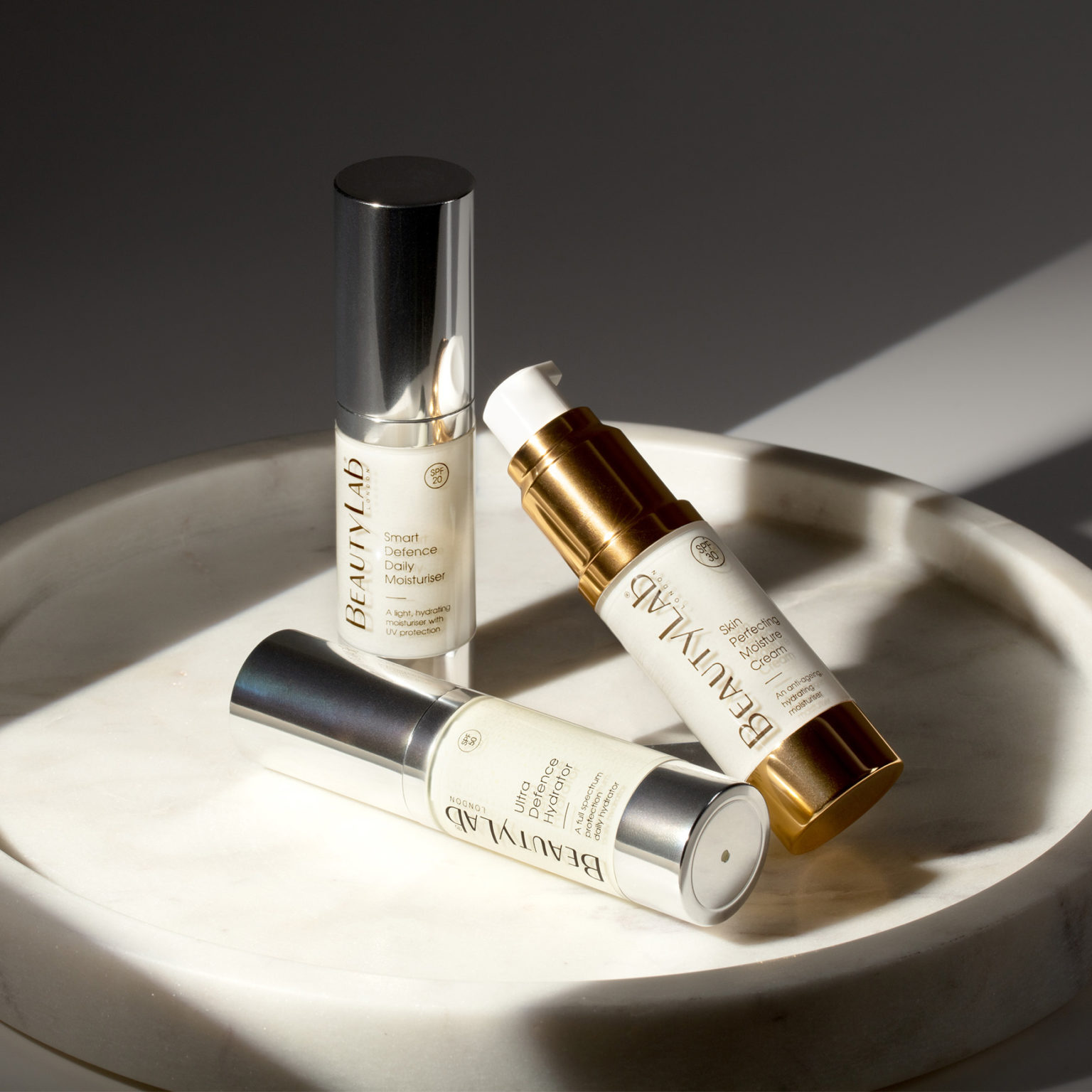 Smart Defence Daily Mosituriser, Skin Perfecting Moisture Cream and Ultra Defence Hydrator promped on top of a white marble tray
