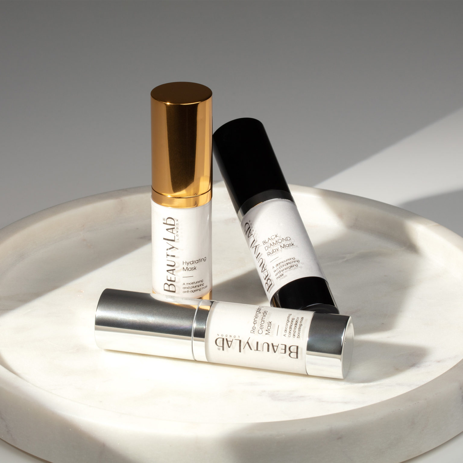 Hydrating Mask, Black Diamond Ruby Mask and Re-energizing Ceramide Mask promped on top of a white marble tray